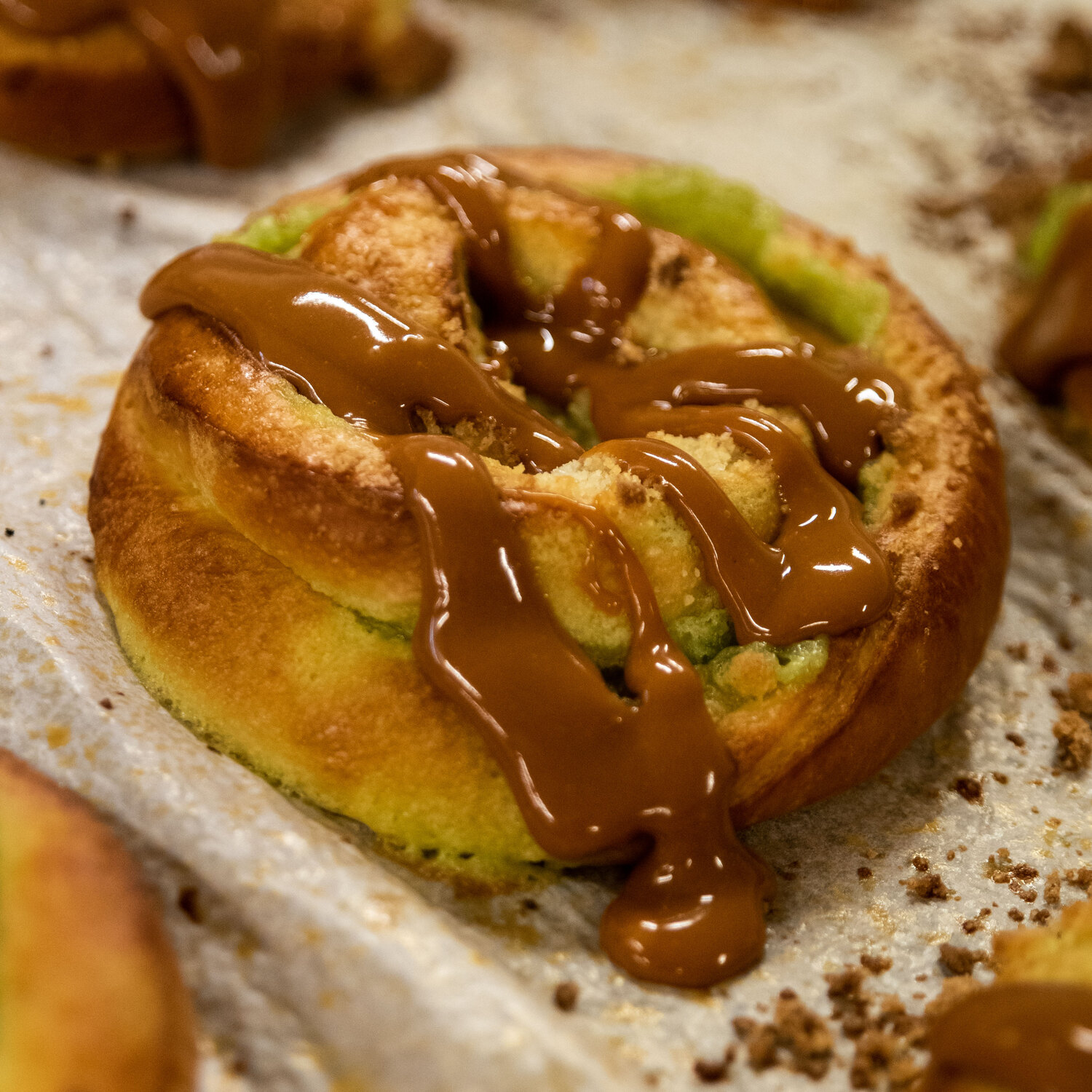 A Reynir pistachio snúður torn open, gooey pistachio glaze stretching between the halves